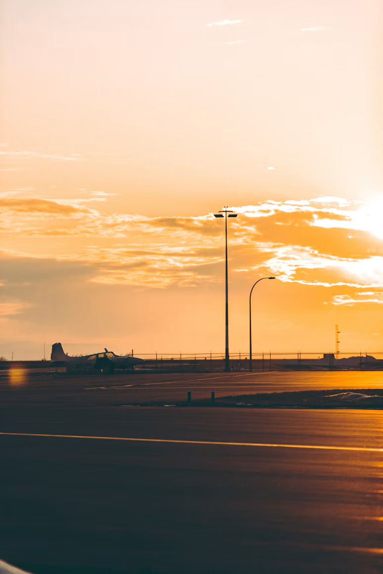 An airport runway beneath a warm sunset