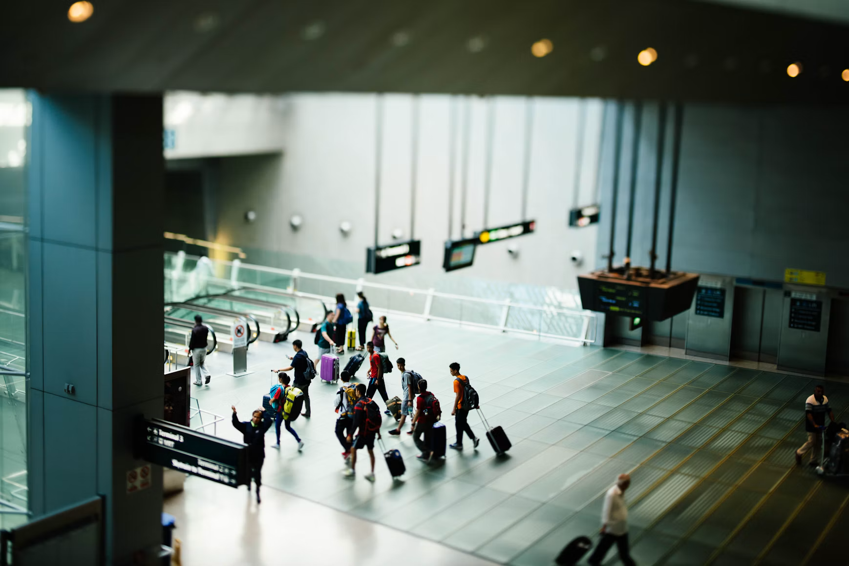 Travellers moving through a modern airport terminal
